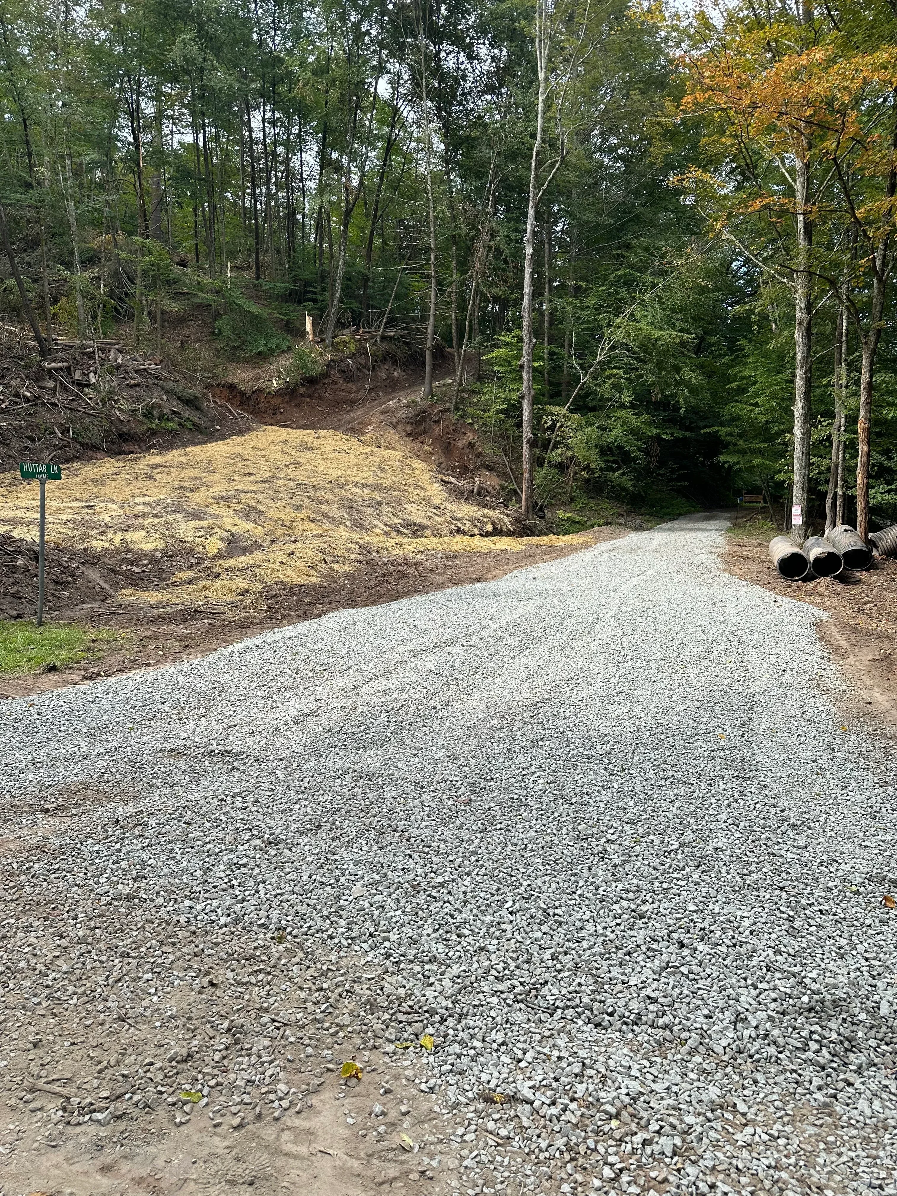 Gravel driveway with cleared tree line and prepared base material